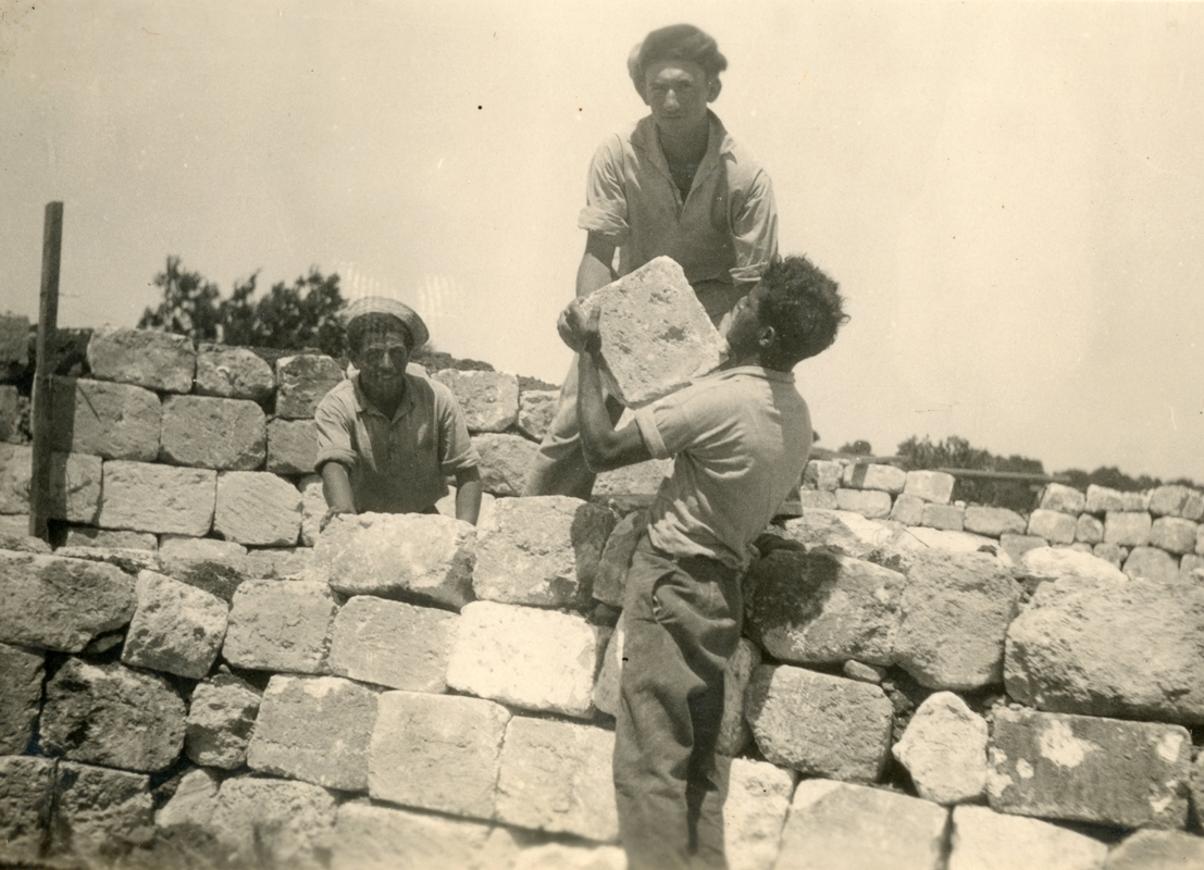 רחביה וחבר מסייעים בבניית החומה בקוסקוס תחתית יוני 1938    תמונה